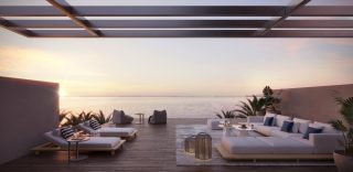 rooftop terrace with lounge seating sea view at sunset