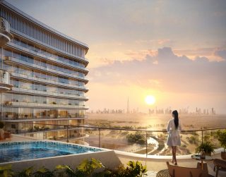 woman on balcony with dubai skyline sunset